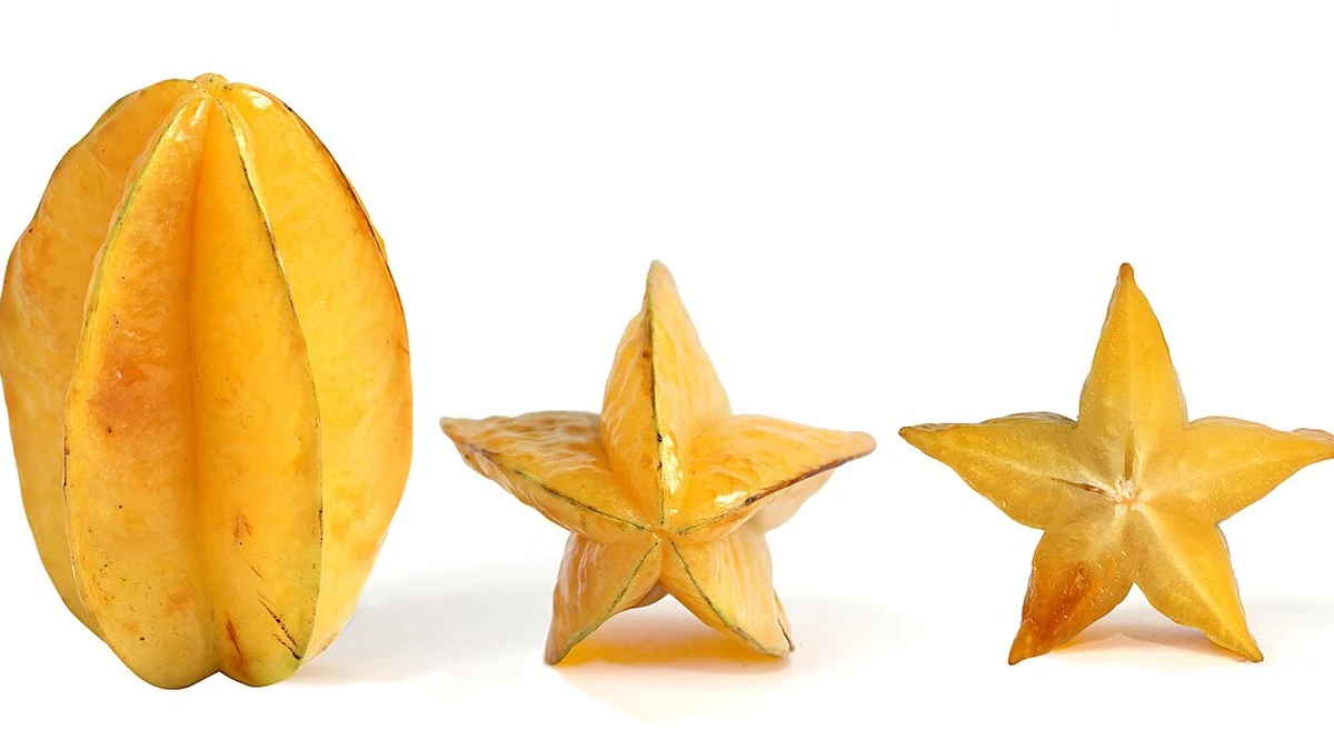 Fruto entero de carambola y rodajas en forma de estrella, sobre fondo blanco