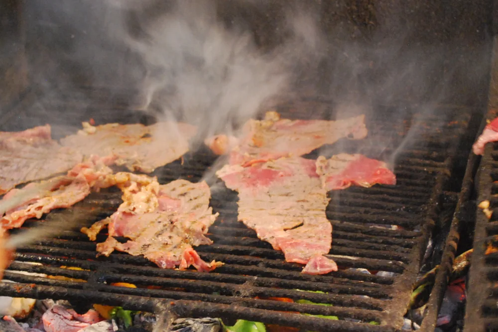 Tasajo asado sobre brasas en un mercado de Oaxaca, México