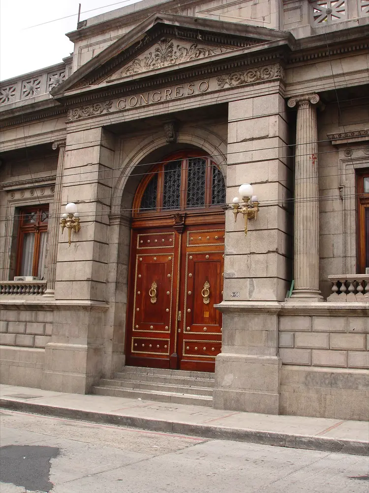 Puerta de madera y entrada de piedra de un edificio histórico con la inscripción Congreso sobre el dintel