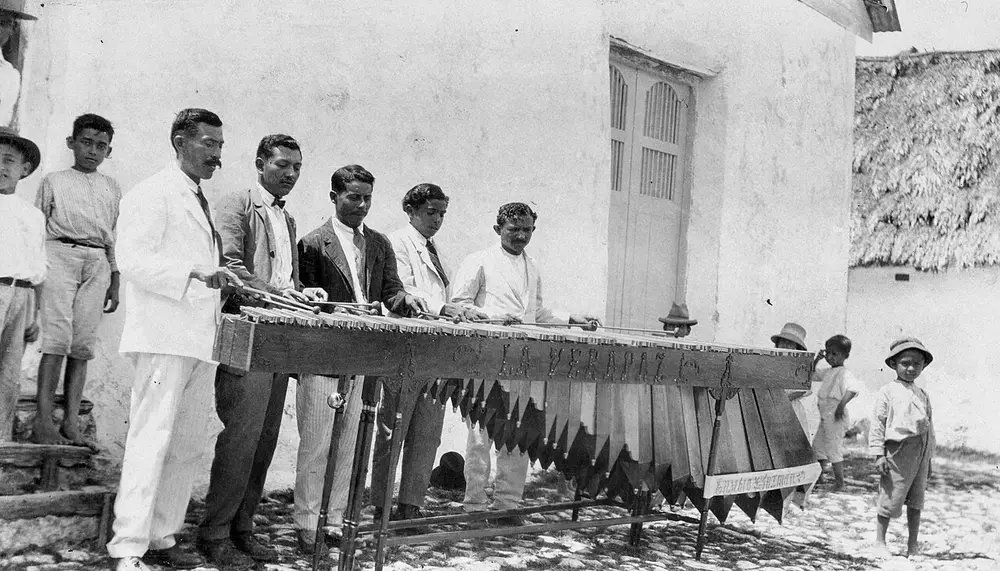 Músicos tocando una marimba de madera en Flores, Petén, en una fotografía de 1923