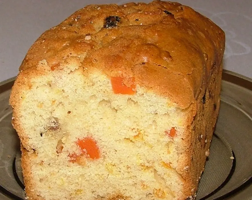 Bizcocho de molde alargado, no el de hueco de esta receta, partido a la mitad: miga amarilla y trozos de fruta confitada anaranjada en el interior