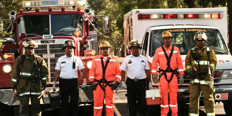 Bomberos voluntarios de Guatemala junto a vehículos de emergencia