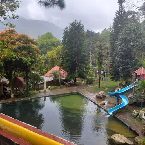Piscina con resbaladero azul y bosque en Eco Centro Chamché