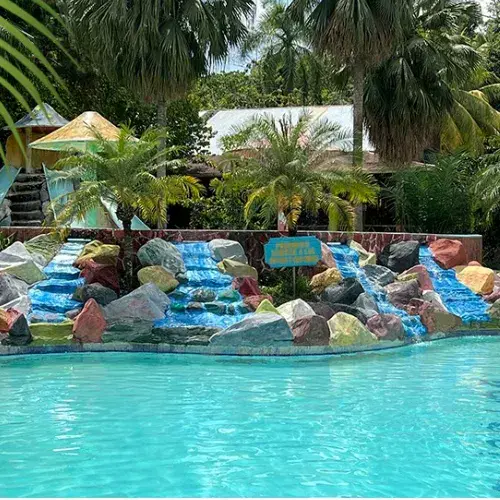 Piscina rodeada de jardines y decoración en Ecocentro La Charca de Don Jerónimo