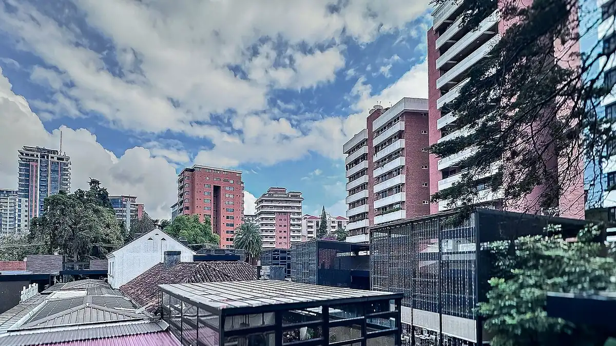 Edificios de varios pisos en la zona 10 de la Ciudad de Guatemala, con árboles y cielo parcialmente nublado