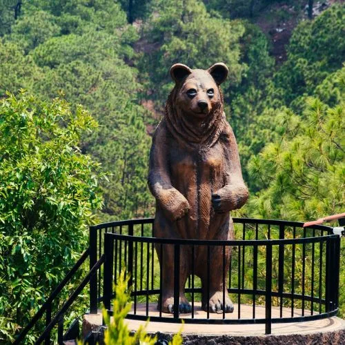 Mirador con figura de oso entre árboles en El Jocotal