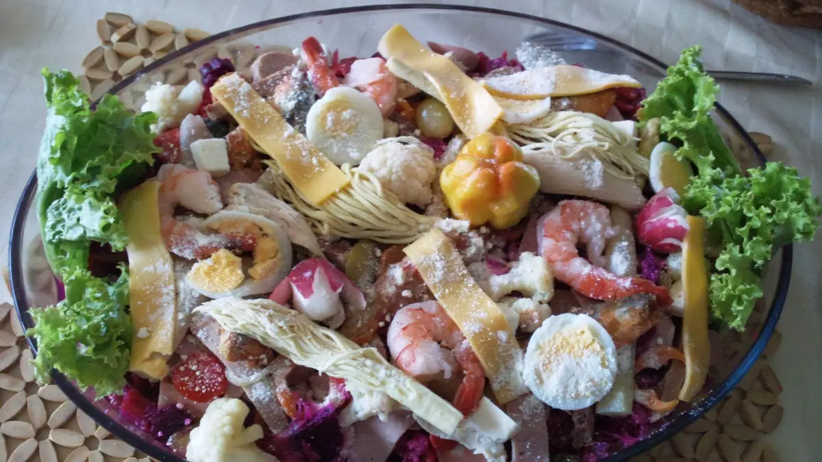 Fuente grande de fiambre guatemalteco con camarones, huevo, queso, palmito y verduras curtidas de colores