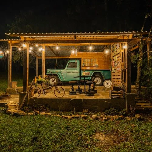 Glamping Jeep iluminado bajo una pérgola en Finca El Valle