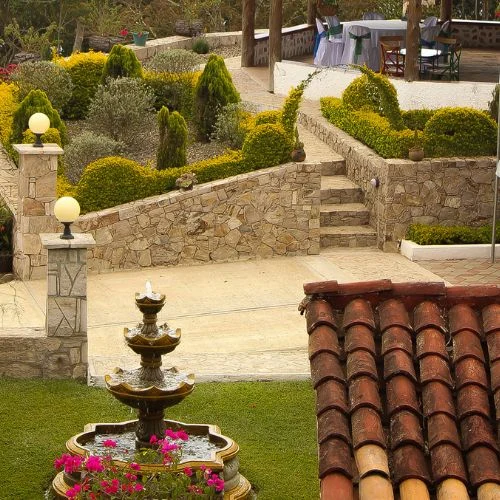 Jardín con fuente y muros de piedra en Finca Zibatá
