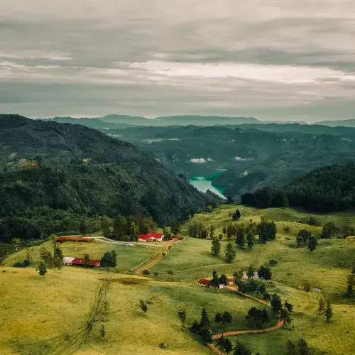 Paisaje de montañas y cenote turquesa visto desde el entorno de Hacienda Nueva Escocia