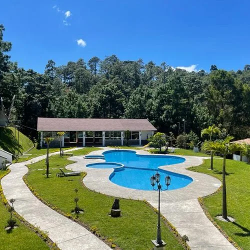 Piscina climatizada rodeada de jardín y bosque en Hacienda Río Escondido