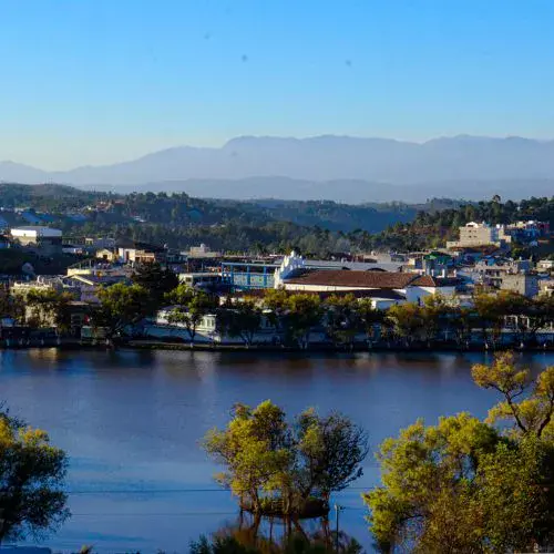 Paisaje de la Laguna Las Garzas con el pueblo y las montañas al fondo
