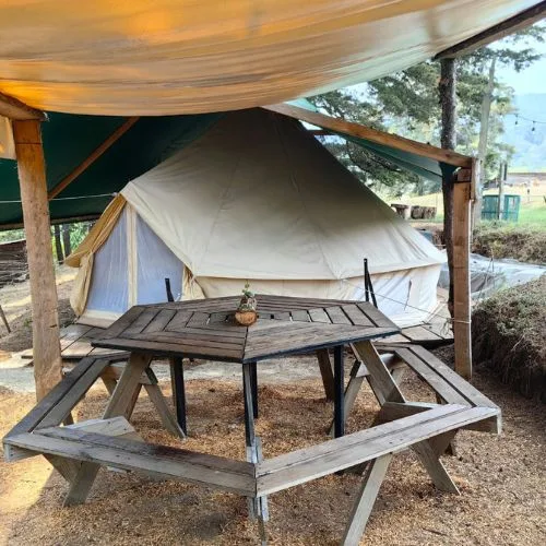 Carpa de glamping con mesa de picnic en Luna Llena Parque de Montaña