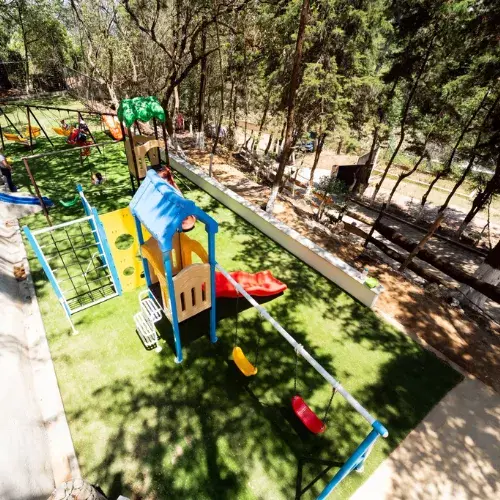 Juegos infantiles rodeados por el bosque en el Parque Ecológico Los Encinos