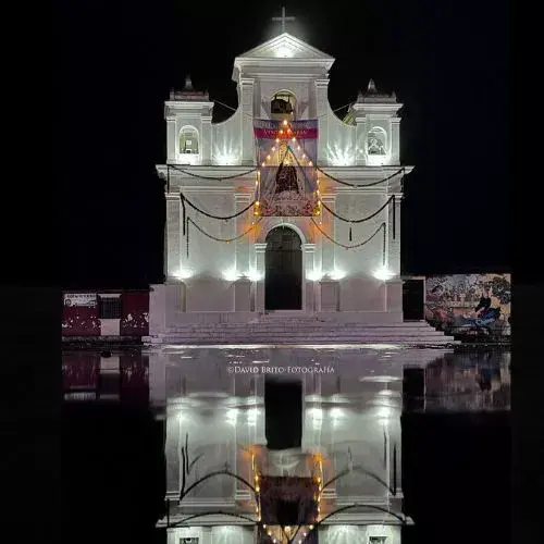 Fachada iluminada de la Parroquia de Santa María Nebaj durante una celebración