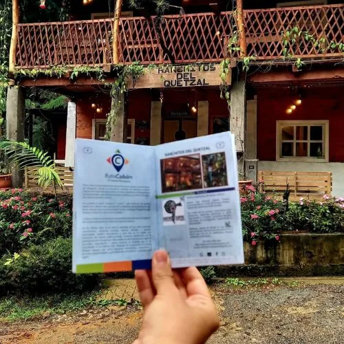Cabaña de madera rodeada de plantas en Ranchitos del Quetzal