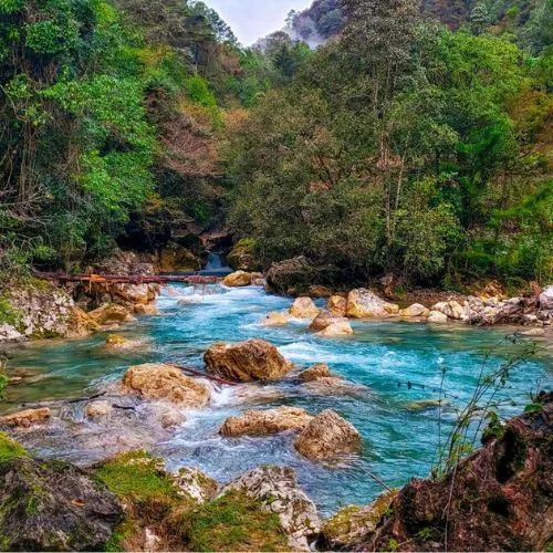Río Quisil de agua clara entre vegetación de Huehuetenango