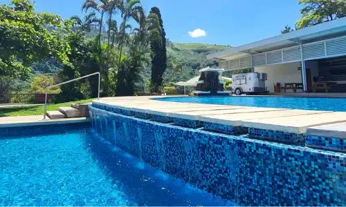 Piscina y edificio de servicios de El Rocarena en un día soleado