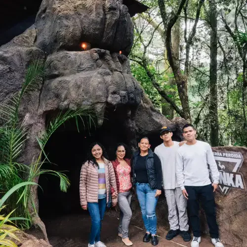Familia frente a una entrada temática de Tierra Perdida en San José Pinula