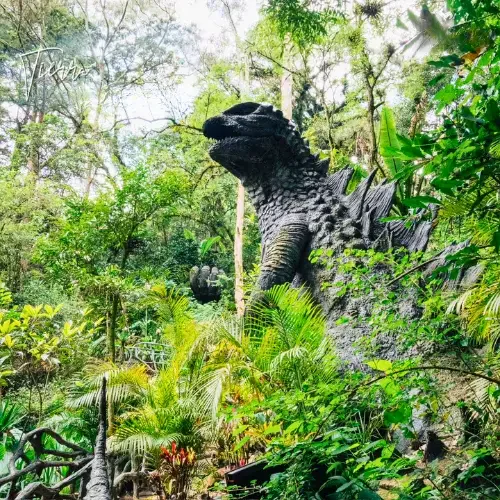 Escultura de una criatura fantástica entre la vegetación de Tierra Perdida