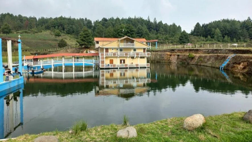Casa y muelle del Turicentro Casa del Lago reflejados en la laguna