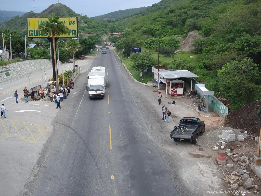 Carretera de dos carriles que atraviesa Guastatoya, con cerros secos y vegetación al fondo