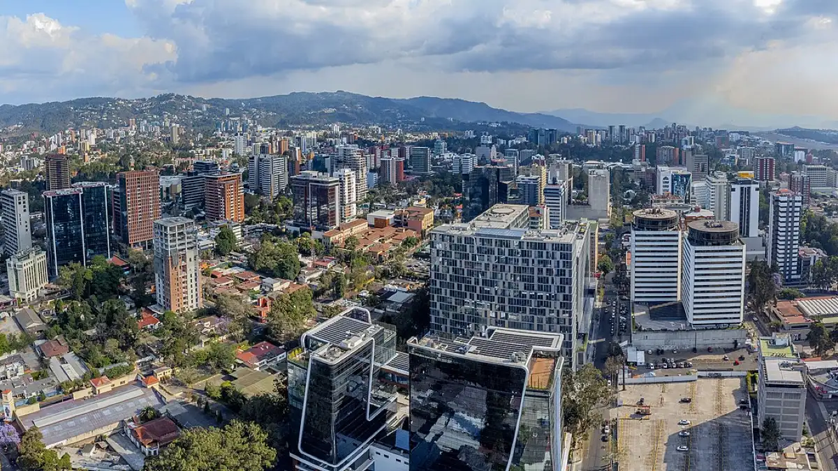 Vista aérea de edificios altos de la zona 10 de la Ciudad de Guatemala, con cerros al fondo