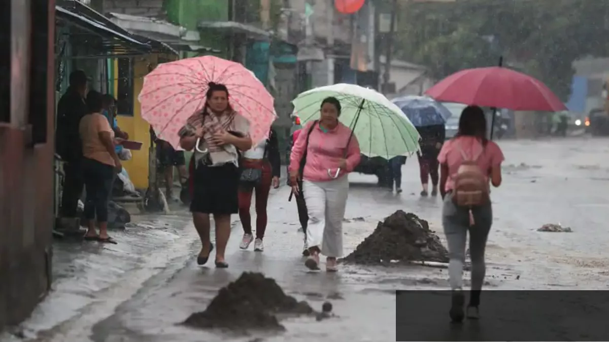 Personas caminando bajo la lluvia en calles de Guatemala